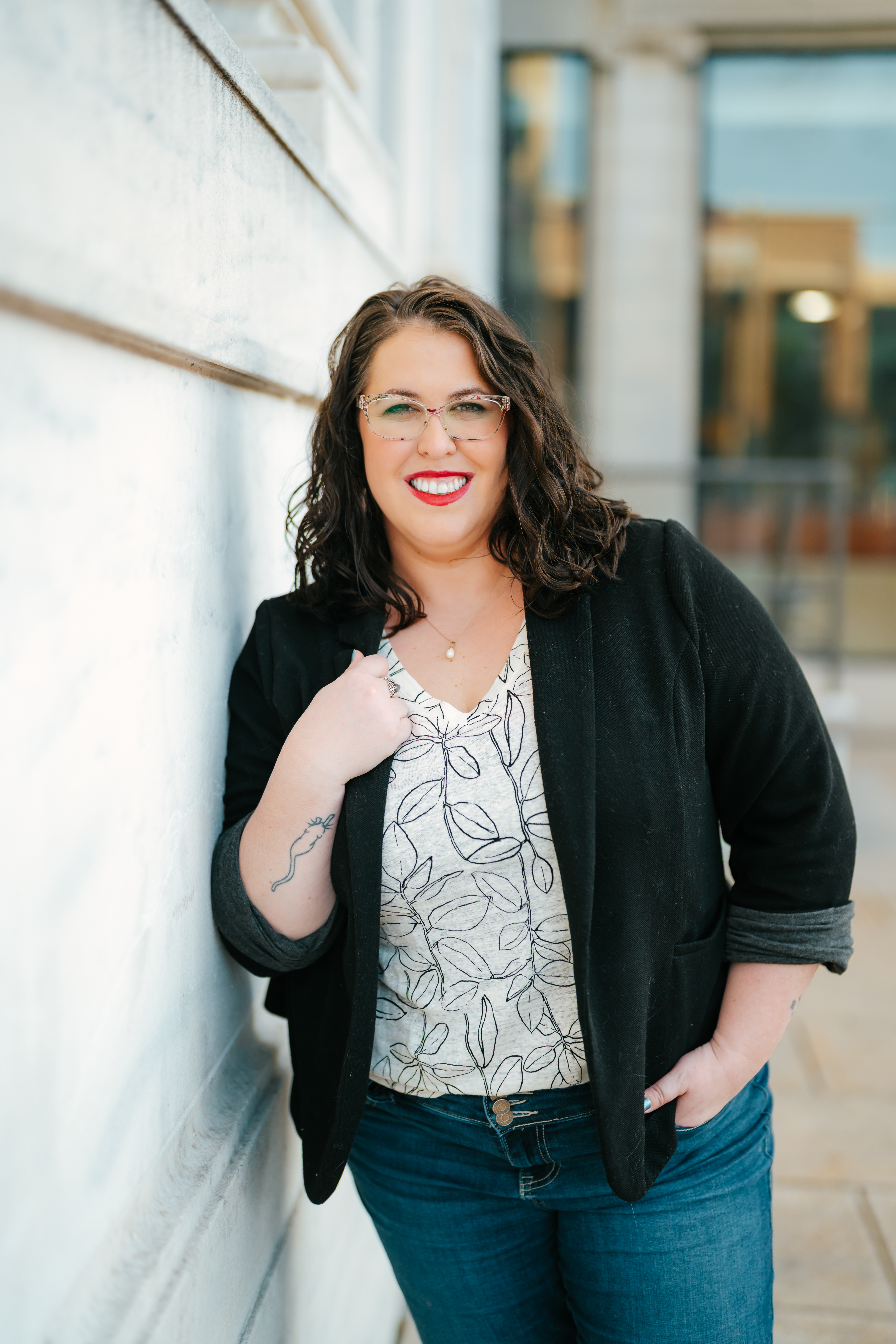 Author Kelsey Winton leaning against a wall